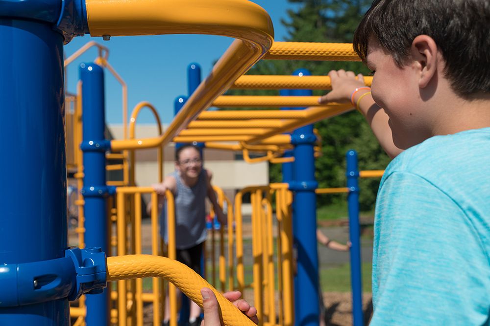 Little boy on monkey bars on school playground