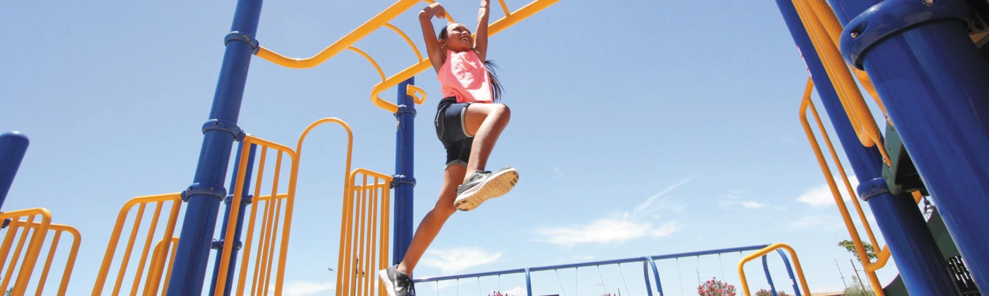 Girl going across monkey bars