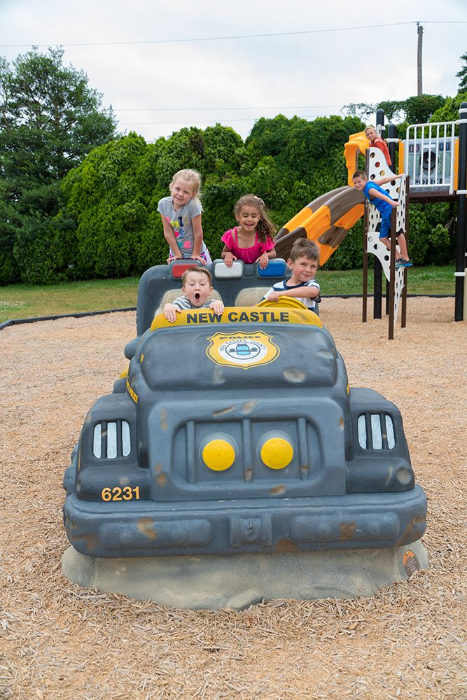 Children playing on car playground structure