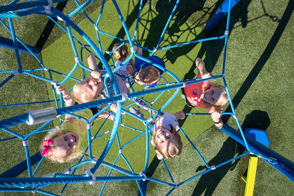 Young girls on blue net playground equipment