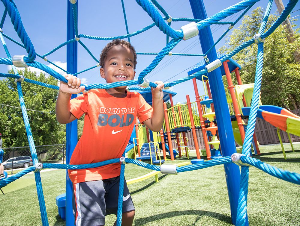Child playing on church playground blue rope climber