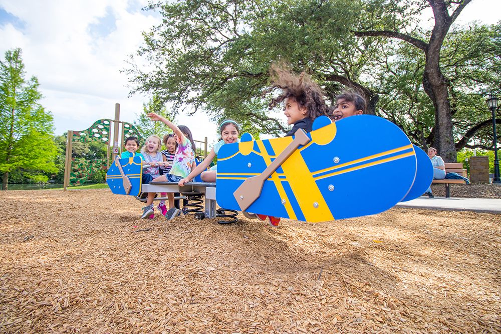 Group of children on canoe playground structure