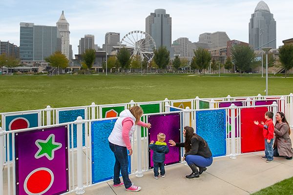 Parents and child playing on interactive panels outside of the city